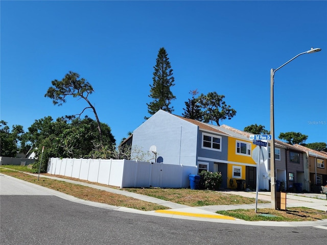 view of property exterior with stucco siding and fence