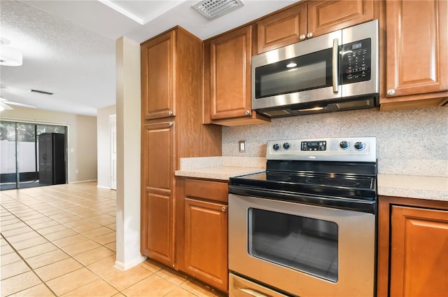 kitchen featuring light tile patterned floors, light countertops, visible vents, and appliances with stainless steel finishes