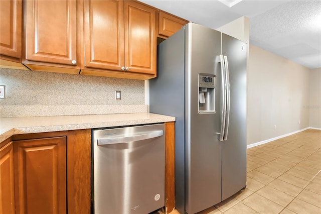 kitchen featuring backsplash, stainless steel appliances, light countertops, and light tile patterned floors