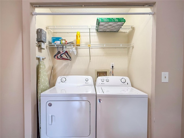 clothes washing area featuring separate washer and dryer and laundry area