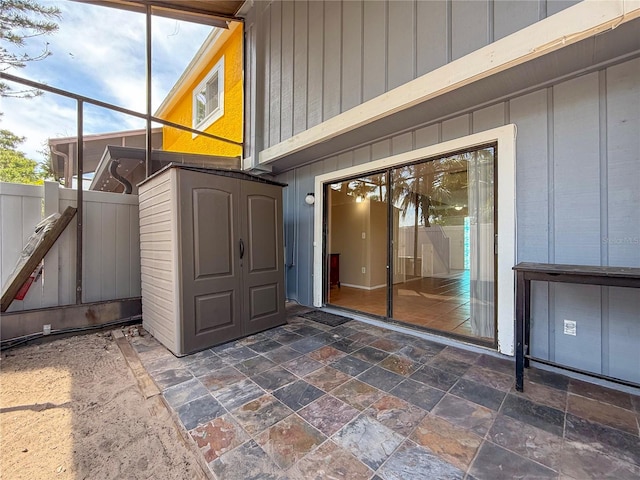 view of exterior entry featuring a patio area and fence