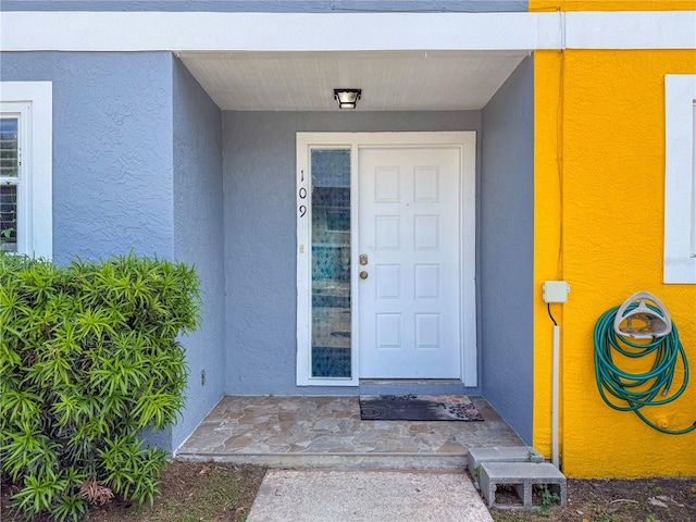view of exterior entry featuring stucco siding