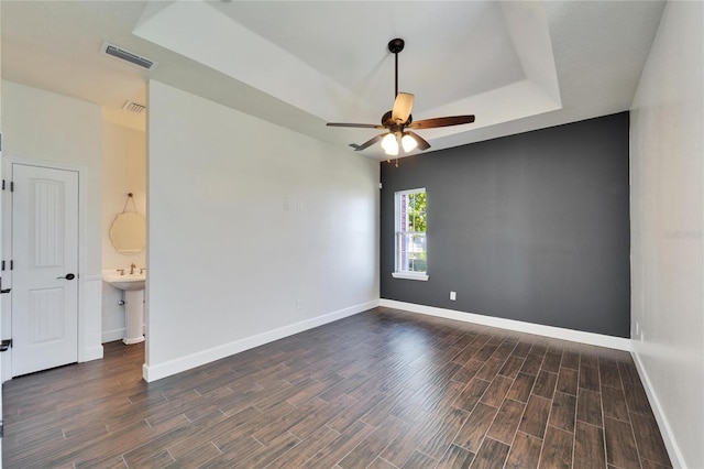 14807 Capps Estates Ln, Wimauma, FL 33598 - empty room featuring a raised ceiling, ceiling fan, and dark wood finished floors