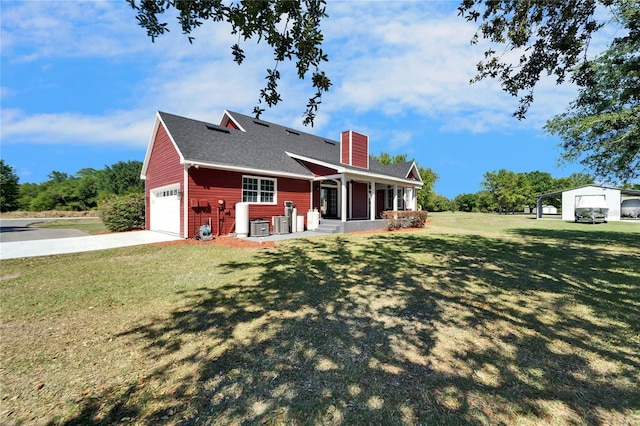 14807 Capps Estates Ln, Wimauma, FL 33598 - rear view of house featuring a chimney, a lawn, driveway, roof with shingles, and covered porch