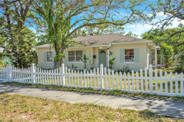 view of front facade featuring stucco siding and a fenced front yard