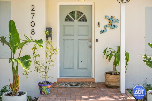 doorway to property featuring stucco siding
