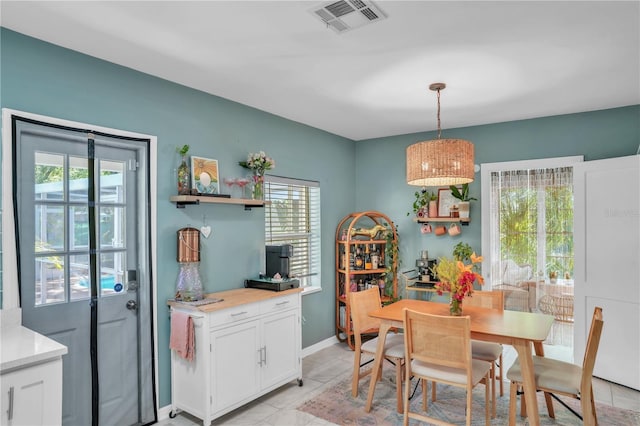 dining space featuring baseboards, visible vents, and light tile patterned floors
