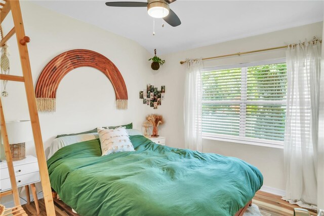 bedroom with a ceiling fan, baseboards, and wood finished floors