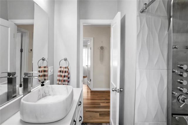 full bathroom featuring vanity, baseboards, walk in shower, and wood finished floors