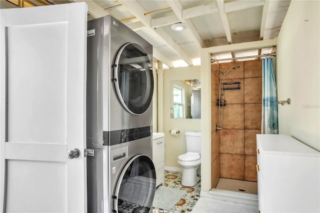 full bathroom featuring a shower stall, toilet, and stacked washing maching and dryer