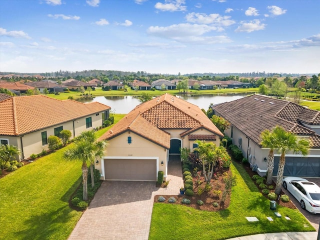 11248 Juglans Dr, Odessa, FL 33556 - view of front of property featuring an attached garage, a water view, a tile roof, and stucco siding