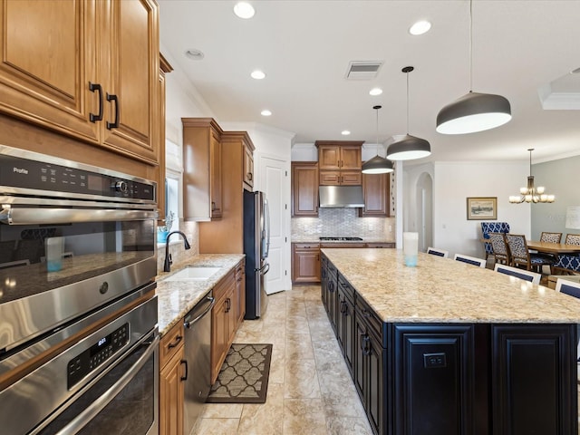 11248 Juglans Dr, Odessa, FL 33556 - kitchen with a center island, under cabinet range hood, a sink, visible vents, and appliances with stainless steel finishes