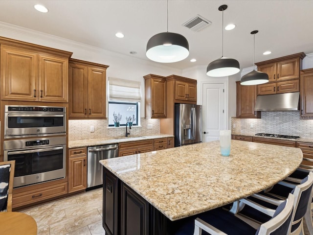 11248 Juglans Dr, Odessa, FL 33556 - kitchen featuring stainless steel appliances, under cabinet range hood, a breakfast bar, a sink, and visible vents