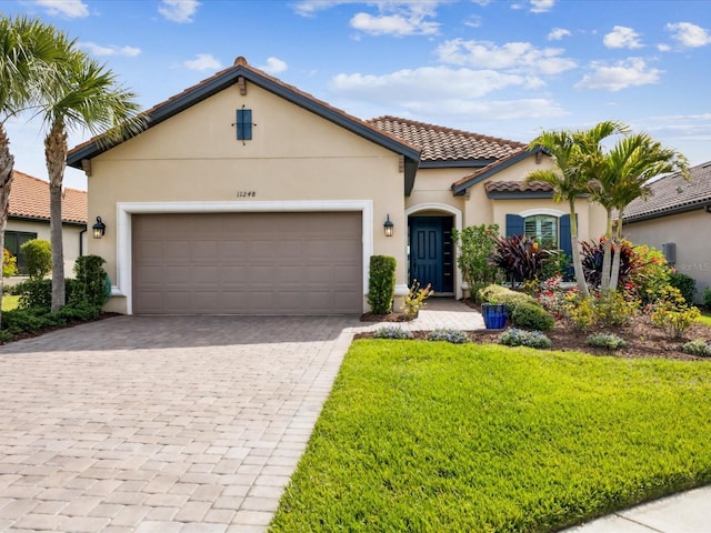 11248 Juglans Dr, Odessa, FL 33556 - mediterranean / spanish-style house featuring a tile roof, decorative driveway, stucco siding, and an attached garage