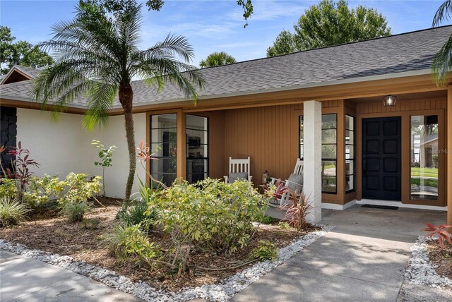 4715 Kemble Ct, Tampa, FL 33624 - doorway to property with covered porch and a shingled roof