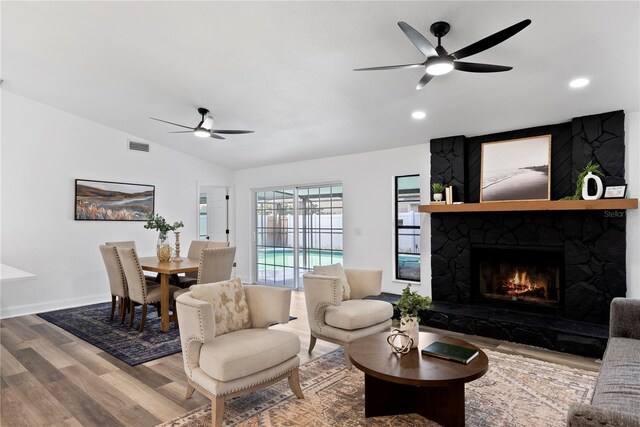 4715 Kemble Ct, Tampa, FL 33624 - living room with a ceiling fan, a stone fireplace, vaulted ceiling, and wood finished floors