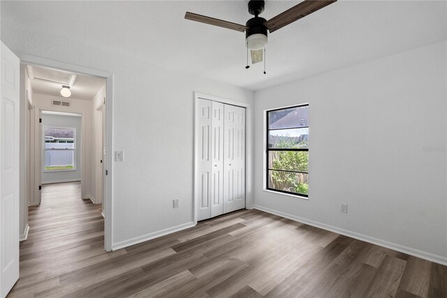 4715 Kemble Ct, Tampa, FL 33624 - unfurnished bedroom with multiple windows, visible vents, wood finished floors, and baseboards