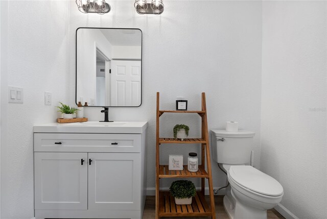 4715 Kemble Ct, Tampa, FL 33624 - bathroom with toilet, vanity, baseboards, and wood finished floors