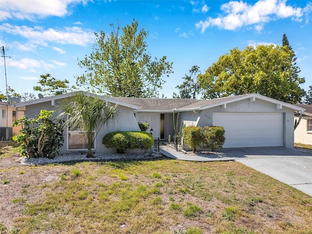 ranch-style house featuring an attached garage, a front lawn, stucco siding, and concrete driveway