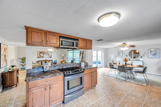 kitchen with ceiling fan, brown cabinetry, a textured ceiling, visible vents, and stainless steel appliances