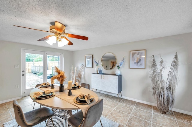 dining area with baseboards, a ceiling fan, a textured ceiling, and light tile patterned floors