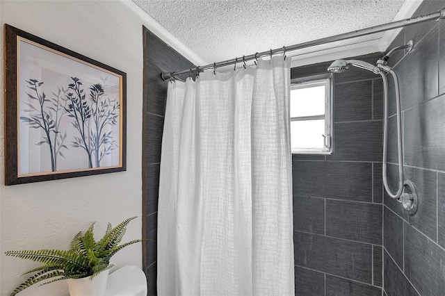 bathroom featuring crown molding, a textured ceiling, toilet, and tiled shower