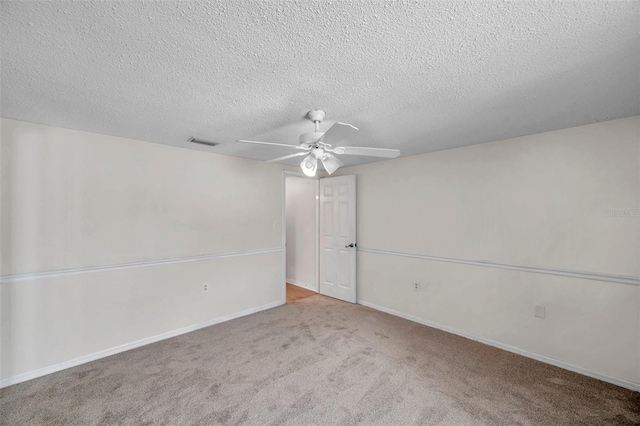 spare room with visible vents, a ceiling fan, carpet, and a textured ceiling