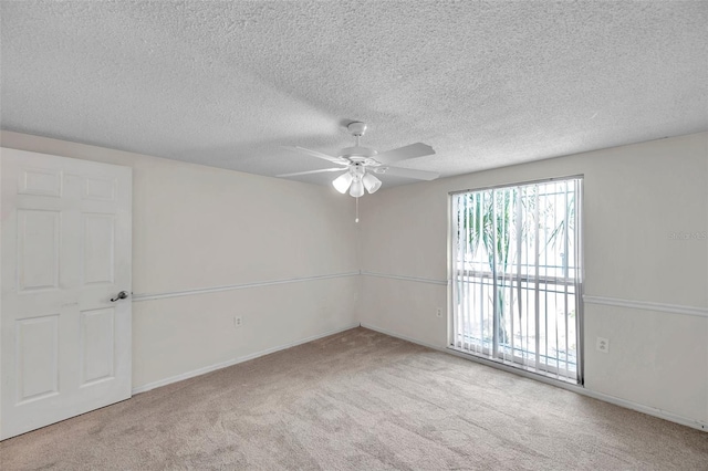 carpeted empty room featuring baseboards, a textured ceiling, and ceiling fan
