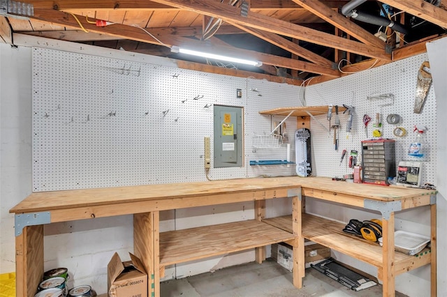 interior space with concrete flooring, electric panel, and a workshop area