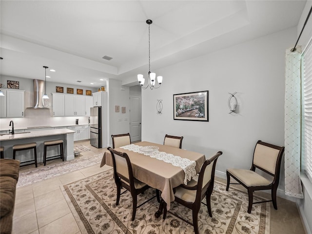 dining space featuring a notable chandelier, a raised ceiling, light tile patterned floors, baseboards, and visible vents