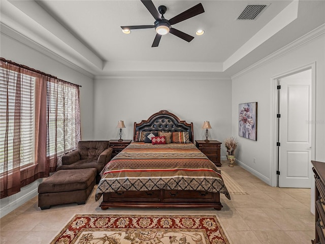 bedroom with ornamental molding, a tray ceiling, baseboards, and visible vents