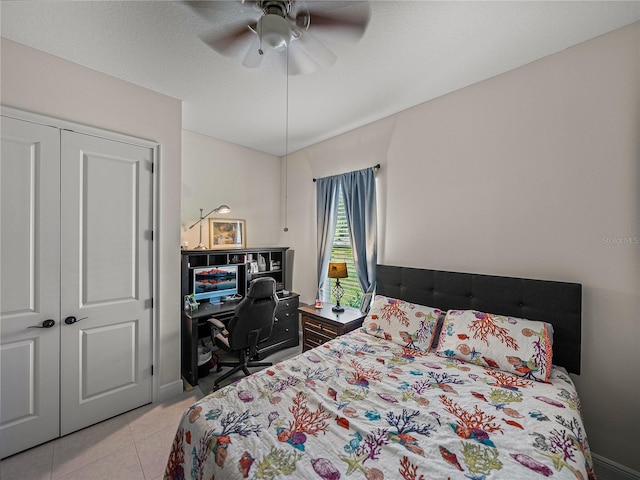 bedroom featuring a closet, a ceiling fan, and light tile patterned floors
