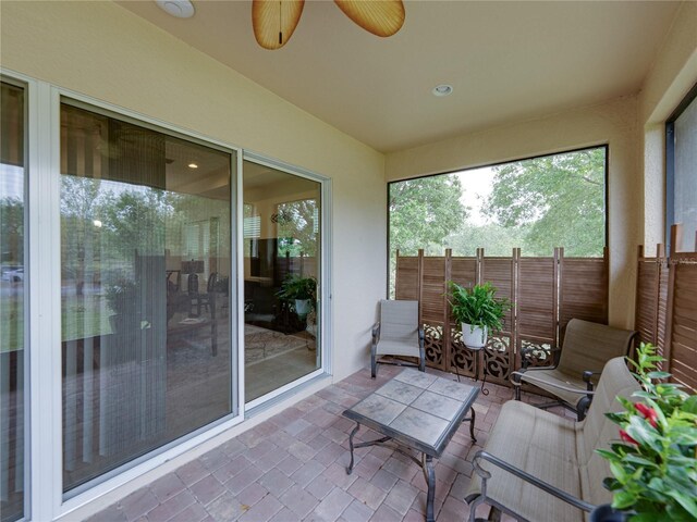 sunroom / solarium featuring a ceiling fan