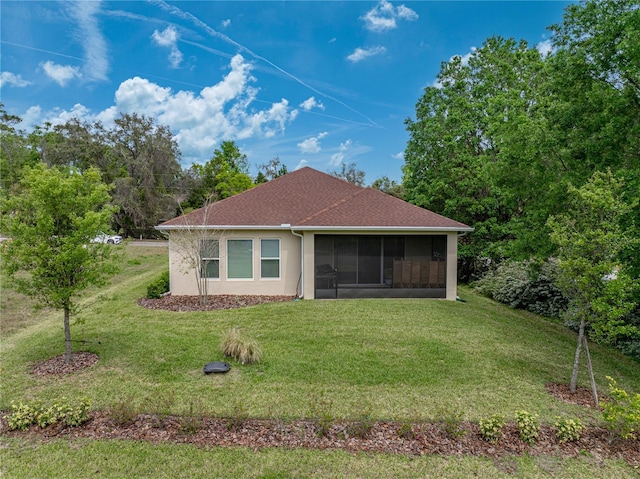 back of property featuring a shingled roof, a lawn, stucco siding, and a sunroom