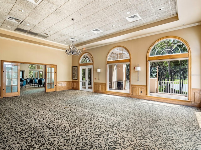 interior space featuring french doors, a wainscoted wall, carpet, and visible vents