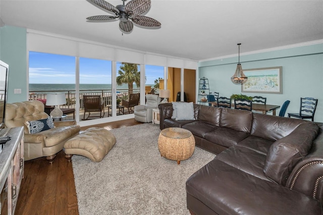 living area featuring dark wood finished floors, a water view, crown molding, and ceiling fan