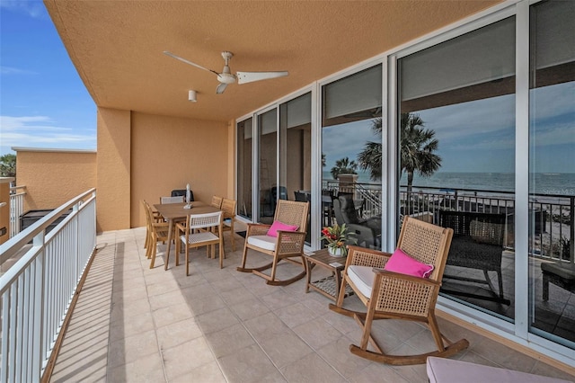 balcony featuring a water view and ceiling fan