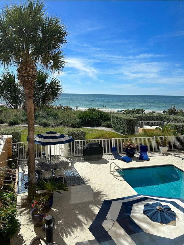 view of swimming pool featuring a patio area, a fenced in pool, a water view, and fence
