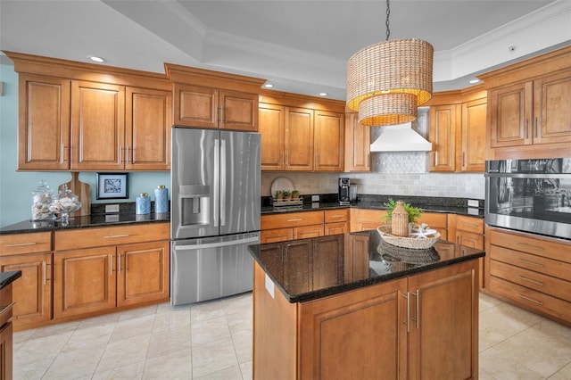 kitchen with stainless steel appliances, custom exhaust hood, brown cabinetry, and a tray ceiling