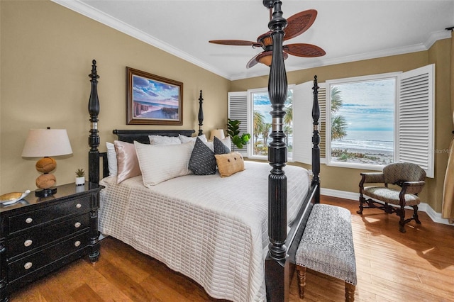 bedroom with wood finished floors, crown molding, baseboards, and a ceiling fan