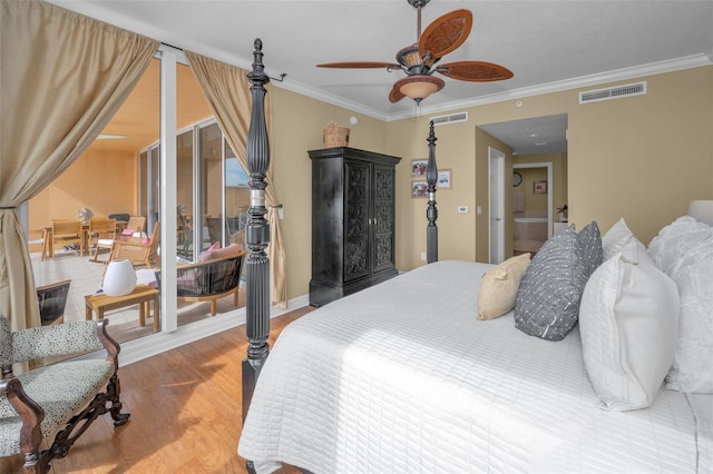 bedroom featuring wood finished floors, visible vents, and ornamental molding
