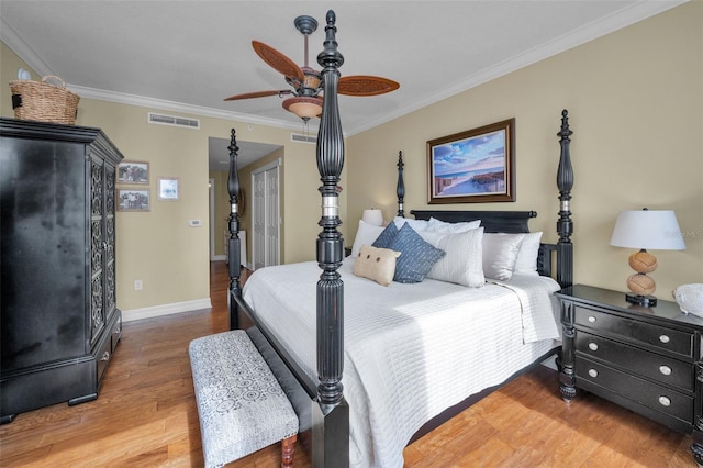 bedroom featuring baseboards, visible vents, a ceiling fan, wood finished floors, and ornamental molding