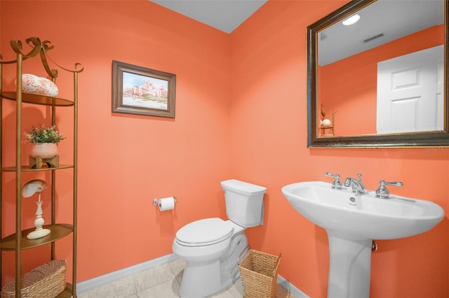 half bathroom with visible vents, toilet, baseboards, and a sink