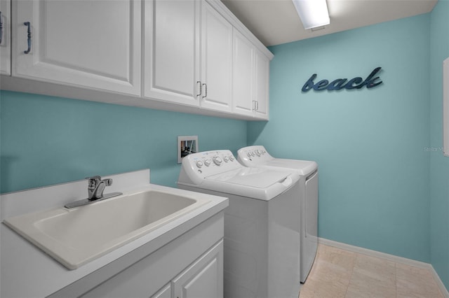 laundry area featuring washing machine and dryer, baseboards, a sink, and cabinet space