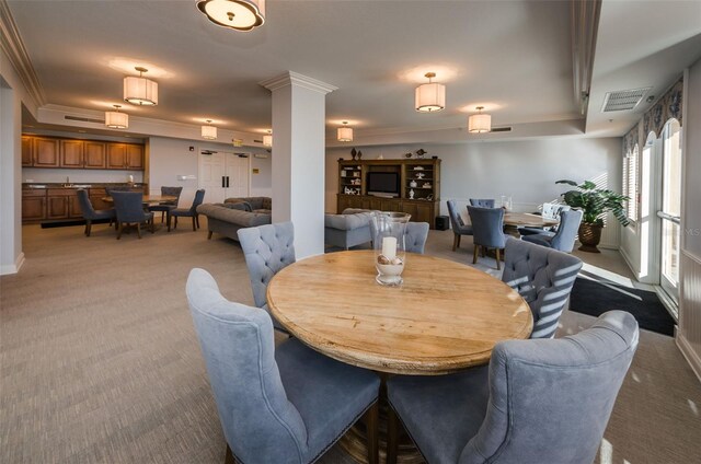 dining space with light colored carpet, baseboards, crown molding, and visible vents
