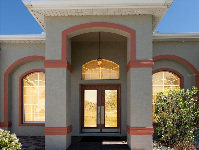 entrance to property featuring brick siding and french doors