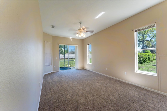 carpeted spare room featuring a ceiling fan, baseboards, and visible vents