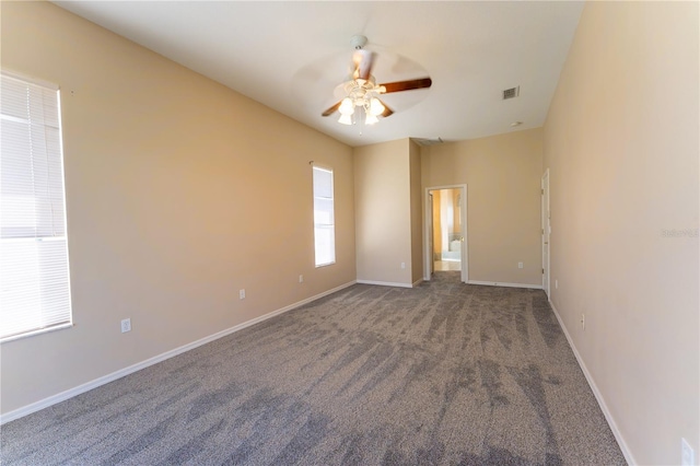 carpeted spare room featuring baseboards, visible vents, and ceiling fan