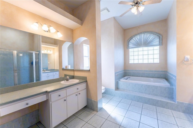 bathroom featuring toilet, a shower stall, a ceiling fan, and plenty of natural light