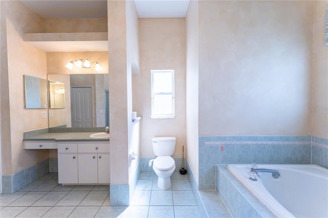 full bath featuring toilet, vanity, a relaxing tiled tub, tile patterned flooring, and baseboards